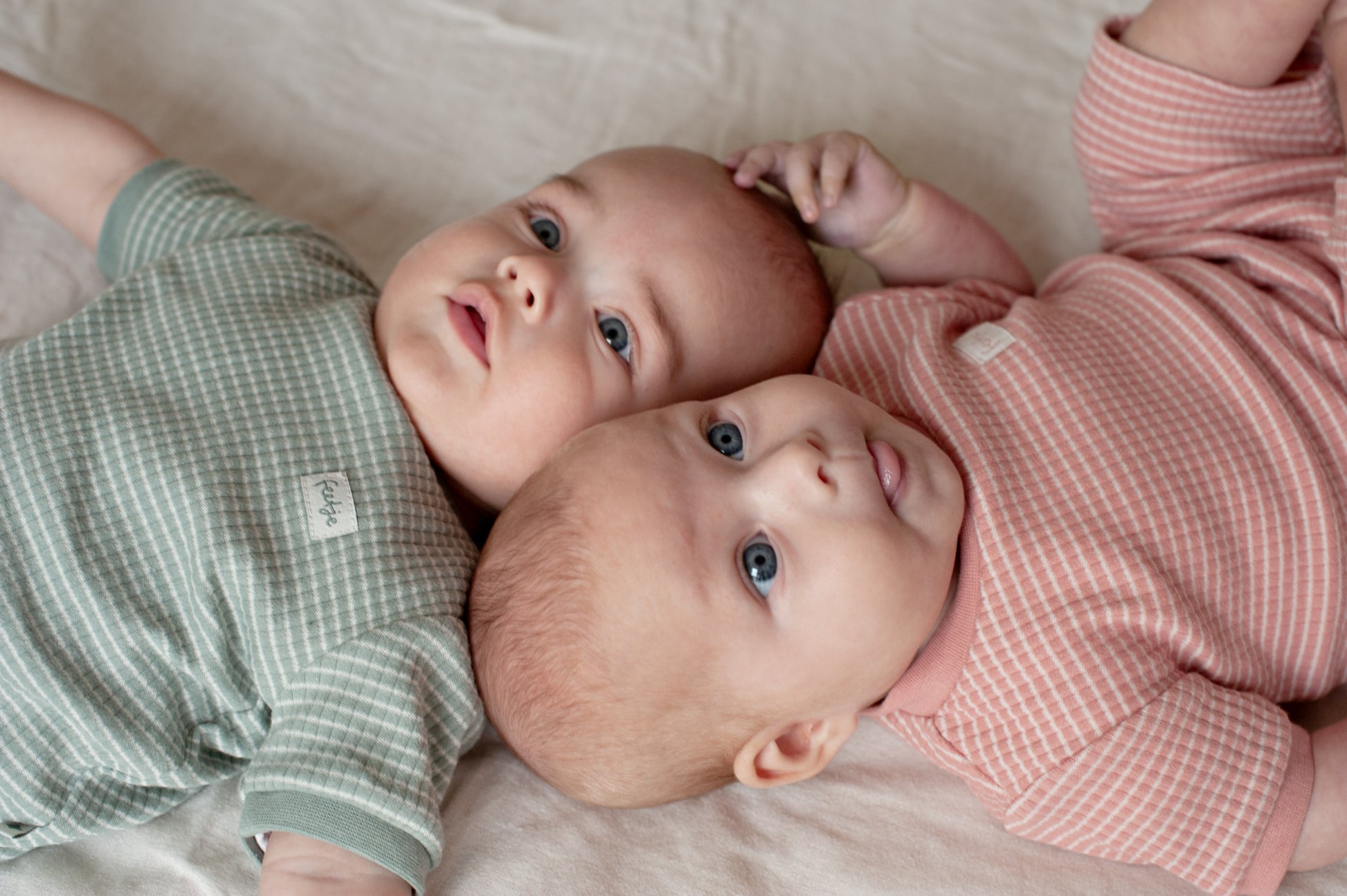 Baby draagt zeegroene Feetje shortama en mauve pyjama 