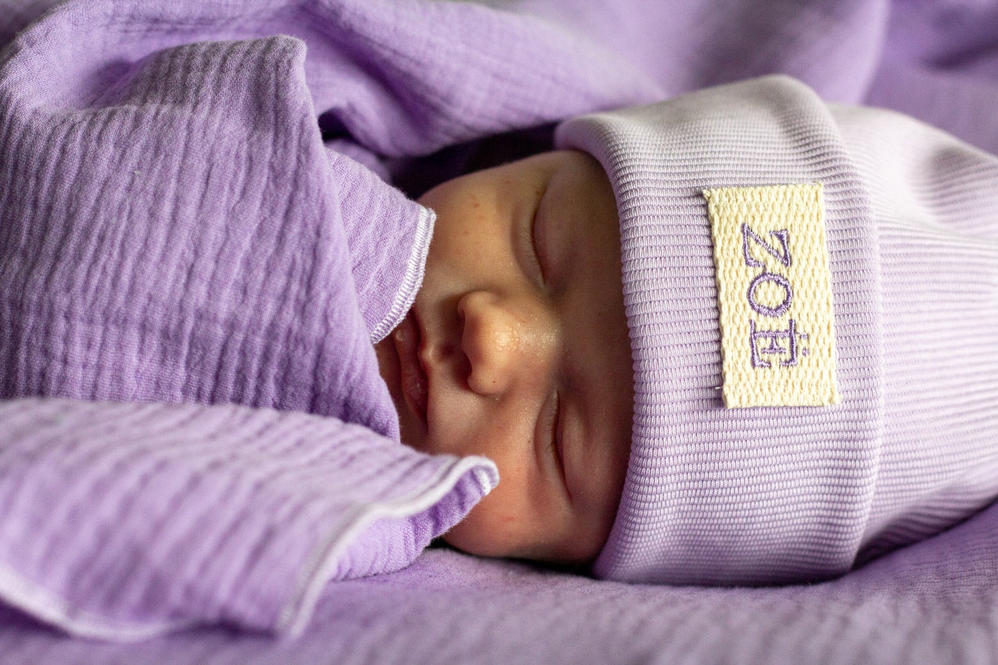 gepersonaliseerde muts met naam lil, ecru label en lila letters